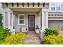 Inviting front porch with room to sit and enjoy the colorful landscaping and sunshine at 612 Ozona Village Dr, Palm Harbor, FL 34683