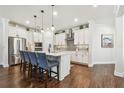 Modern kitchen with white cabinets, stainless steel appliances, pendant lighting and breakfast bar seating at 612 Ozona Village Dr, Palm Harbor, FL 34683