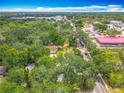 Aerial view showcases a charming yellow house surrounded by lush greenery, capturing its serene landscape at 6901 N 19Th St, Tampa, FL 33610