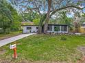 Inviting single-story home with lush lawn, mature trees, and a private screened-in porch at 6901 N 19Th St, Tampa, FL 33610