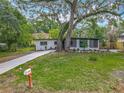 Attractive single-story home with a lush front lawn and mature trees offering shade and character at 6901 N 19Th St, Tampa, FL 33610