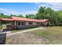 Front exterior view featuring red roof, brick accents, and walkway at 7095 South St, Webster, FL 33597