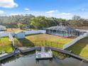 Aerial view of a spacious backyard, featuring a pool, shed, and waterfront access with a wooden deck at 7325 Calder Dr, New Port Richey, FL 34653