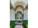 Inviting entryway featuring double doors, arched window, brick walkway and manicured shrubs at 8926 Garner Ct, Trinity, FL 34655