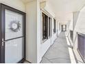 Hallway leading to unit with decorative wreath on door and concrete floor at 9425 Blind Pass Rd # 802, St Pete Beach, FL 33706