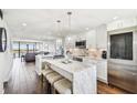 Bright, open kitchen with island, marble countertops, stainless steel appliances, and wood floors at 9425 Blind Pass Rd # 802, St Pete Beach, FL 33706
