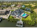 Aerial view showcasing a backyard pool, patio, and dock on the water at 945 Bunker View Dr, Apollo Beach, FL 33572