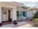 Close-up of the front entrance with vibrant flower accents, outdoor seating and red tile at 9511 45Th N St # 9511, Pinellas Park, FL 33782