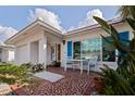 Inviting front porch with outdoor seating area, colorful tile flooring, and lush tropical landscaping at 9511 45Th N St # 9511, Pinellas Park, FL 33782