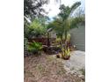 Charming house features a wooden deck, a small palm tree, and other plants in the landscaped backyard at 10502 Atlee St, New Port Richey, FL 34654