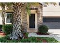 Beautiful front door with stone accents, covered porch, and well maintained landscaping at 11760 Winterset Cove Dr, Riverview, FL 33579