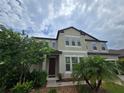Two-story home featuring a dark front door, neutral stucco exterior and mature landscaping at 11839 Cross Vine Dr, Riverview, FL 33579