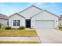 Well-maintained single-Gathering home featuring a two-car garage and manicured front lawn at 12008 Fern Blossom Dr, Gibsonton, FL 33534