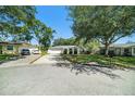 Wide angle view of a quaint home with a spacious driveway and well-manicured front lawn at 135 Rodney Ct, Palm Harbor, FL 34684