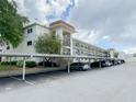 Exterior view of condo building featuring parking, landscaping, and architectural details at 1375 Doolittle Ln # 101, Dunedin, FL 34698