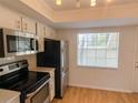 Kitchen featuring stainless steel appliances and white cabinetry at 1375 Doolittle Ln # 101, Dunedin, FL 34698