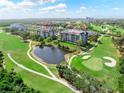 Picturesque aerial view of the condo complex, a pond, and the manicured golf course in the surrounding community at 14820 Rue De Bayonne # 208, Clearwater, FL 33762