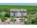 Elevated view of the condo building with a well-manicured landscape, ample parking, and an adjacent scenic pond at 14820 Rue De Bayonne # 208, Clearwater, FL 33762