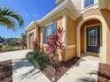 Charming home featuring an arched entryway with a glass door and dark blue shutters at 1723 Whitewillow Dr, Wesley Chapel, FL 33543