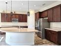Modern kitchen boasts stainless steel appliances, dark wood cabinets, and granite counters for a sleek look at 1723 Whitewillow Dr, Wesley Chapel, FL 33543
