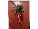 Image of the red front door with a decorative red ribboned wreath at 1799 N Highland Ave # 170, Clearwater, FL 33755