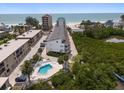 Breathtaking aerial view showcasing the condo with a pool and proximity to the beautiful beach at 19727 Gulf Blvd # 210, Indian Shores, FL 33785