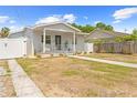 Single-story home featuring a well-maintained lawn, inviting front porch, and white picket fencing at 212 N Bradford Ave, Tampa, FL 33609