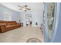 Cozy living room featuring tile floors, a comfortable leather sofa, and an open doorway to the kitchen at 212 N Bradford Ave, Tampa, FL 33609