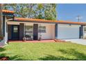Charming home with a brick-accented front, orange tiled roof, and well-manicured lawn, plus an attached garage at 2156 Greenbriar Blvd, Clearwater, FL 33763
