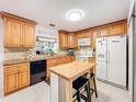 Well-equipped kitchen featuring wooden cabinets, appliances, and an island with bar seating at 3078 Pointer Dr, Palm Harbor, FL 34683