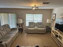 Cozy living room featuring neutral tones, recessed lighting, and comfortable seating; window provides natural light at 3132 Royal Tuscan Ln, Valrico, FL 33594