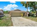 Inviting single-Gathering home with a stone facade, an attached garage, and a beautifully maintained lawn, perfect for outdoor activities at 4101 Hollowtrail Dr, Tampa, FL 33624