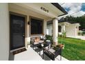 Inviting front porch seating area with a cozy chair and potted plants at 4106 N Thatcher, Tampa, FL 33614
