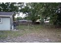 View of the backyard with mature trees and a chain-link fence at 4114 E Sewaha St, Tampa, FL 33617