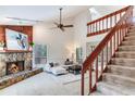 Open living room featuring stone fireplace, wood paneling, vaulted ceiling and staircase with wood accents at 4802 W Dryad St, Tampa, FL 33629
