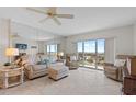 Bright living room with tile floors, comfortable seating, and sliding glass doors to a balcony with scenic views at 4900 Brittany S Dr # 808, St Petersburg, FL 33715