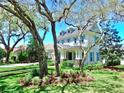 Beautiful home with lush landscaping, mature trees, and classic architecture creates a welcoming ambiance at 5318 Candler View Dr, Lithia, FL 33547