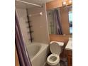 Clean bathroom featuring a shower-tub combo, toilet, vanity, and ample storage space at 5820 N Church Ave # 260, Tampa, FL 33614