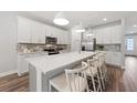 Bright kitchen featuring white cabinets, stainless steel appliances, a large island, and modern pendant lighting at 5953 Bluestar Ct, Lakewood Ranch, FL 34211