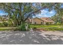 Well-maintained one-story home featuring a lush front lawn and mature trees at 6407 E 112Th Ave, Temple Terrace, FL 33617