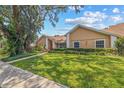 Lovely one-story home with a pristine front lawn and professionally landscaped garden at 6407 E 112Th Ave, Temple Terrace, FL 33617
