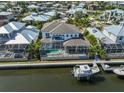 Aerial shot featuring a waterfront home with a screened pool, boat lift, and dock, ideal for boating enthusiasts at 715 Pinckney Dr, Apollo Beach, FL 33572