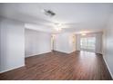 Bright and airy living room featuring wood-look floors, ceiling fan, and sliding doors at 9413 Stonewall Ln, New Port Richey, FL 34655