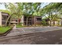 Exterior of a two-story condo building featuring a screened in porch and reserved parking at 11708 Raintree Village Blvd # A, Temple Terrace, FL 33617