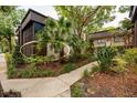 The exterior of a condo building with mature landscaping and a screened-in porch at 11708 Raintree Village Blvd # A, Temple Terrace, FL 33617