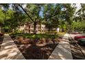 Exterior grounds and entryway of a two-story condo building landscaped with mature trees at 11708 Raintree Village Blvd # A, Temple Terrace, FL 33617