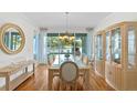 Bright dining area with views of the lake, features a glass table, and display case at 13548 Lake Magdalene Dr, Tampa, FL 33613