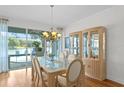 Bright dining area with views of the pool, features a glass table, and display case at 13548 Lake Magdalene Dr, Tampa, FL 33613