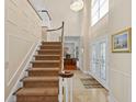 Grand foyer with a soaring ceiling, elegant chandelier, and staircase leading to upper level at 13548 Lake Magdalene Dr, Tampa, FL 33613
