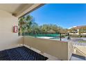 Outdoor balcony with black patterned rug and views of mature trees and a tennis court at 13608 S Village Dr # 6203, Tampa, FL 33618